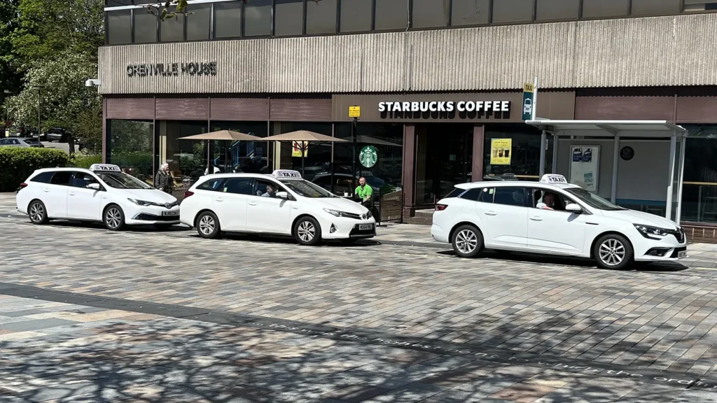 a group of black taxis on a street
